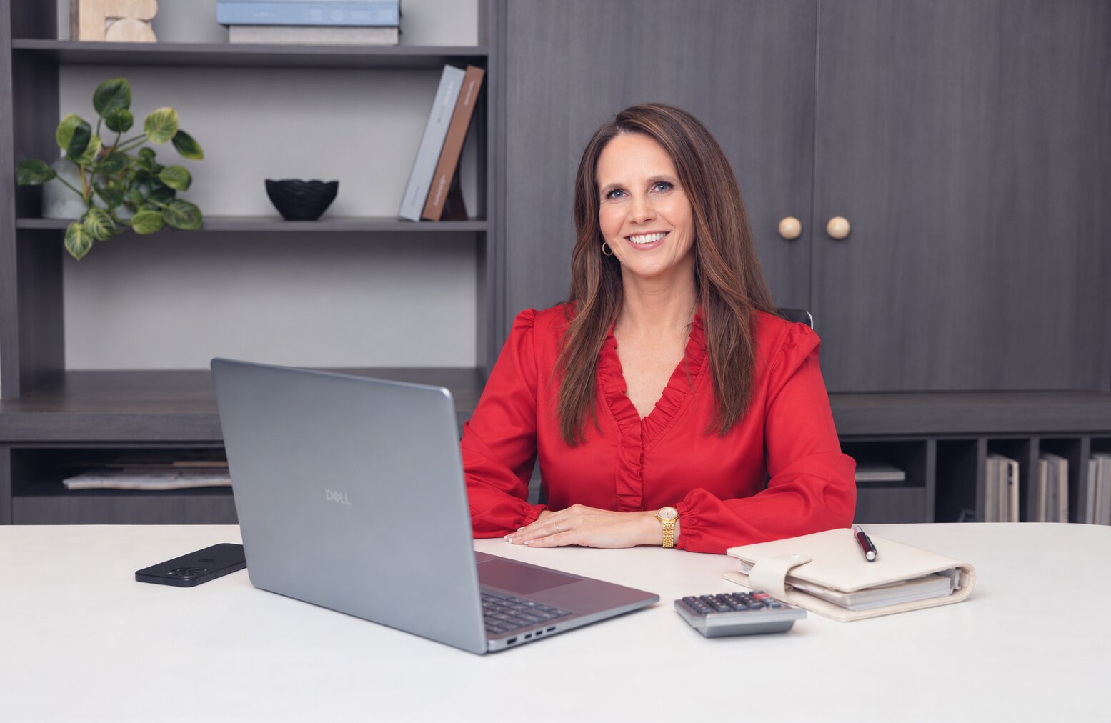 Lynda Hall of Precisely Profit at her desk with a laptop